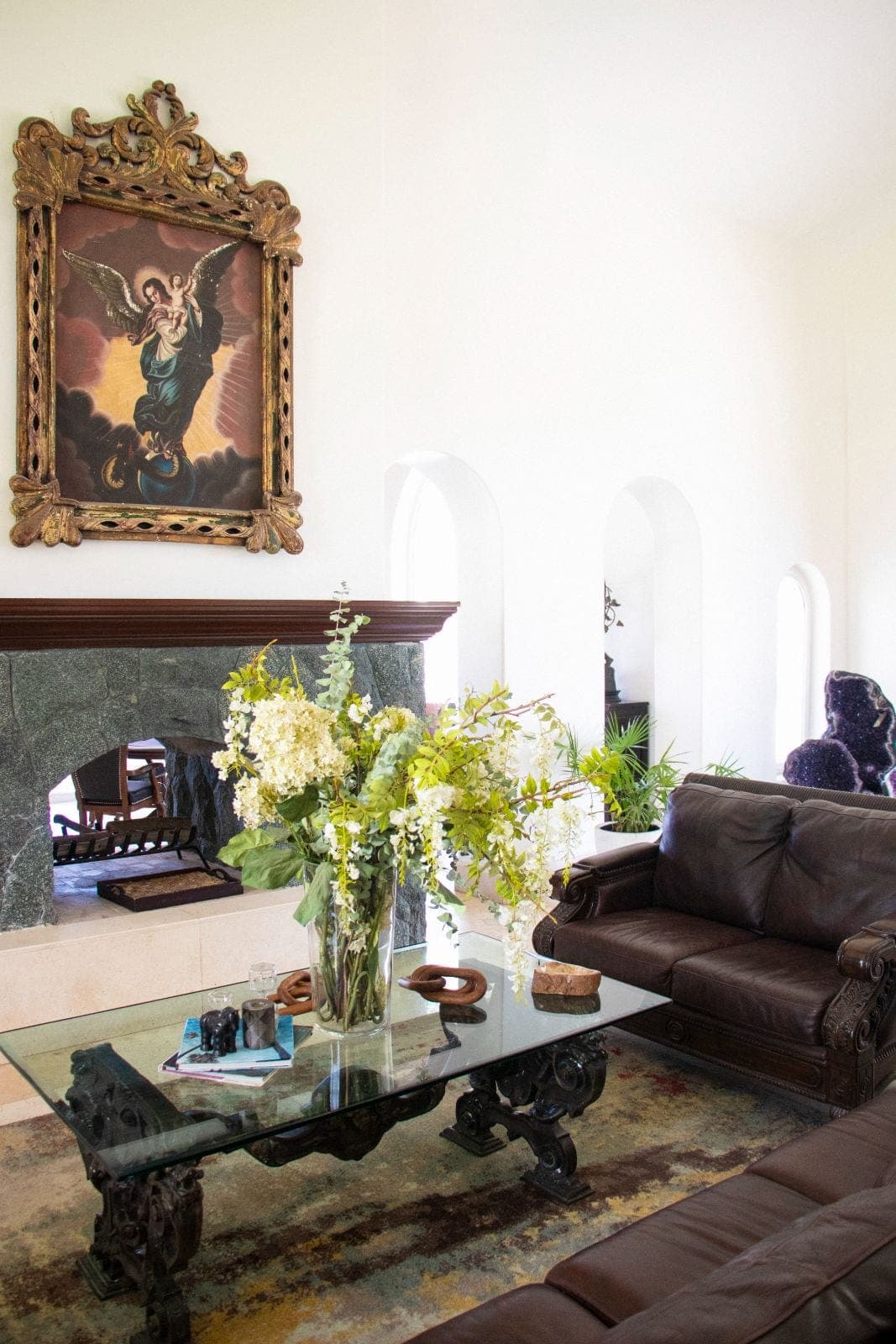 Salón principal con chimenea de piedra y colección de arte antiguo
